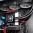 A high-performance gaming computer setup showing the interior components, including a GeForce RTX graphics card, cooling system with three fans, a motherboard, and visible wiring with red and black cables.