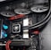 A high-performance gaming computer setup showing the interior components, including a GeForce RTX graphics card, cooling system with three fans, a motherboard, and visible wiring with red and black cables.